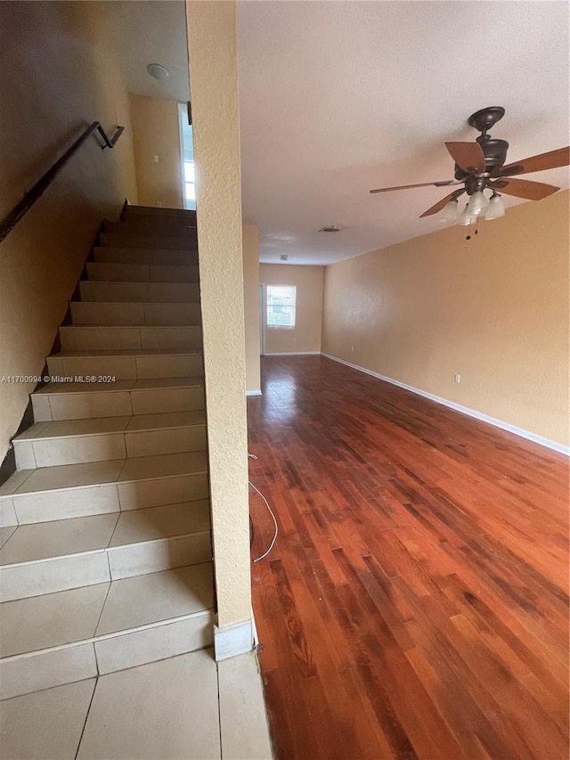 stairway featuring ceiling fan and hardwood / wood-style floors