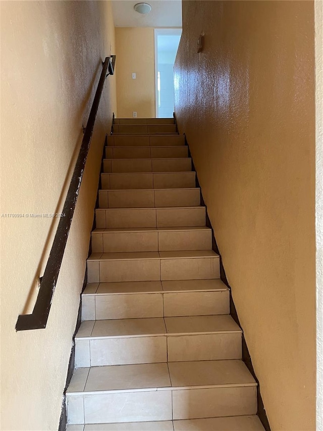 staircase featuring tile patterned flooring