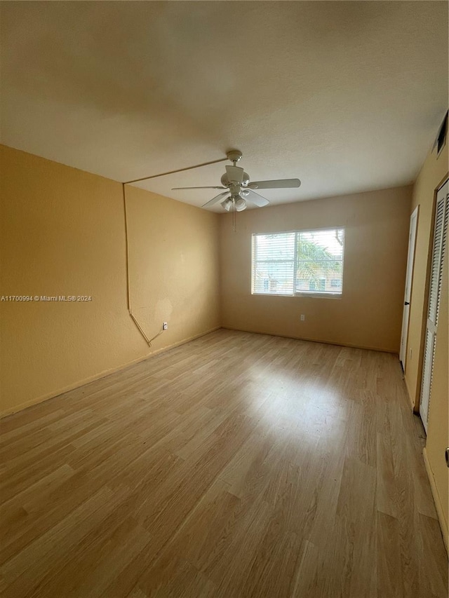 empty room with light hardwood / wood-style flooring and ceiling fan