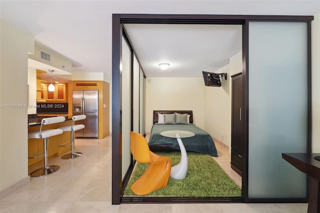 bedroom with stainless steel fridge with ice dispenser