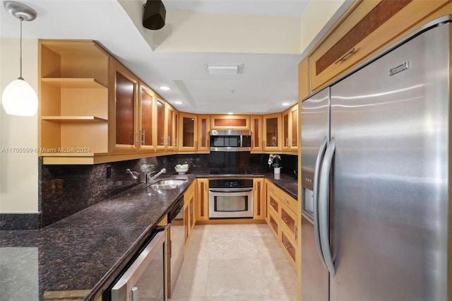 kitchen with decorative backsplash, pendant lighting, stainless steel appliances, and dark stone counters