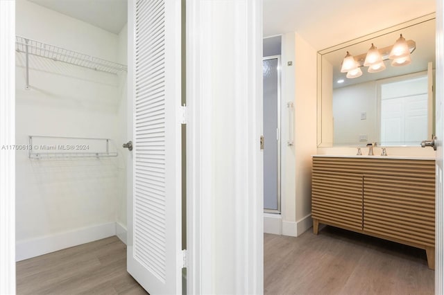 bathroom featuring vanity, wood-type flooring, and walk in shower