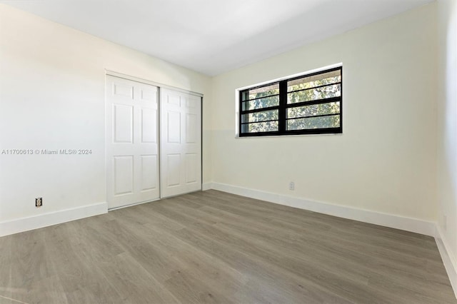 unfurnished bedroom featuring hardwood / wood-style floors and a closet