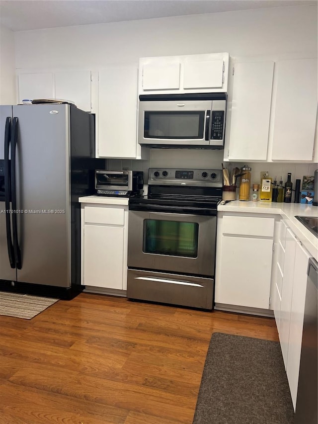 kitchen featuring light hardwood / wood-style floors, white cabinetry, and stainless steel appliances