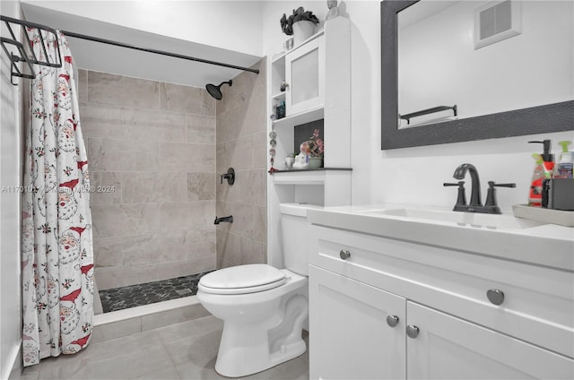 bathroom featuring tile patterned flooring, vanity, toilet, and walk in shower