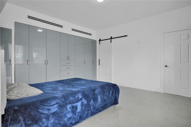 tiled bedroom featuring a barn door