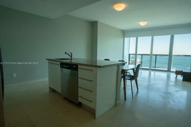 888 Biscayne Blvd Unit 3806, Miami, FL 33132 - kitchen with stainless steel dishwasher, expansive windows, a sink, a center island with sink, and white cabinets