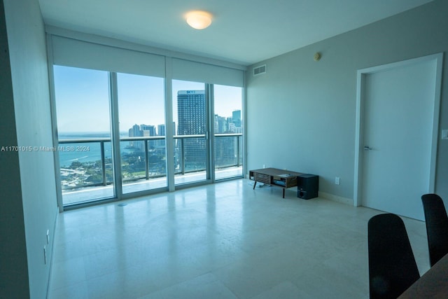 empty room with plenty of natural light, floor to ceiling windows, and a water view