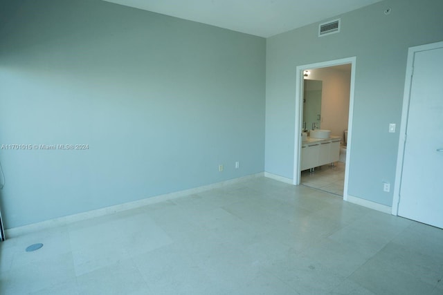 unfurnished bedroom featuring ensuite bath and sink