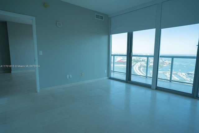 888 Biscayne Blvd Unit 3806, Miami, FL 33132 - spare room with a wall of windows, a smoke detector, and tile patterned floors