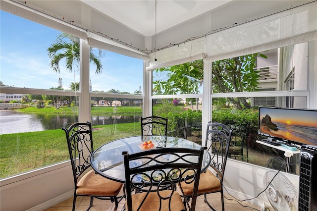 sunroom featuring a water view