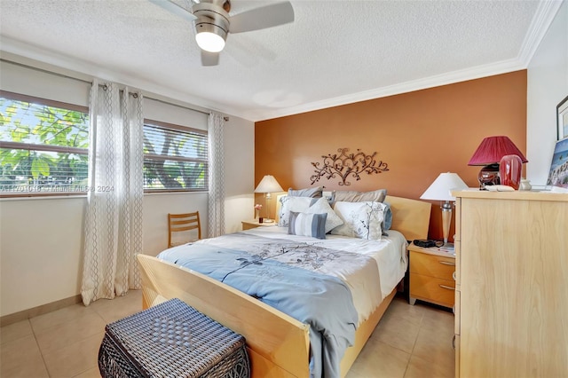 bedroom with ceiling fan, light tile patterned flooring, ornamental molding, and a textured ceiling