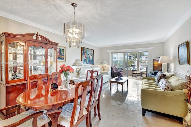 tiled dining area with a notable chandelier, ornamental molding, and a textured ceiling