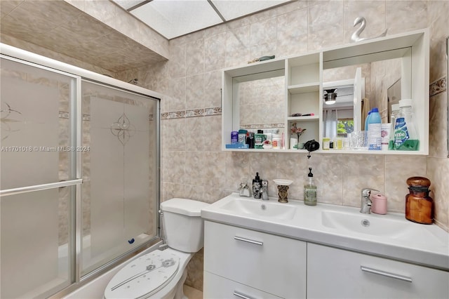 bathroom with decorative backsplash, vanity, tile walls, and toilet