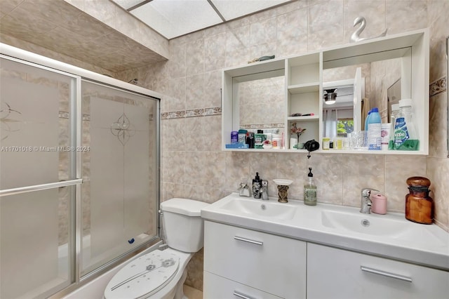 bathroom featuring vanity, toilet, tile walls, and backsplash