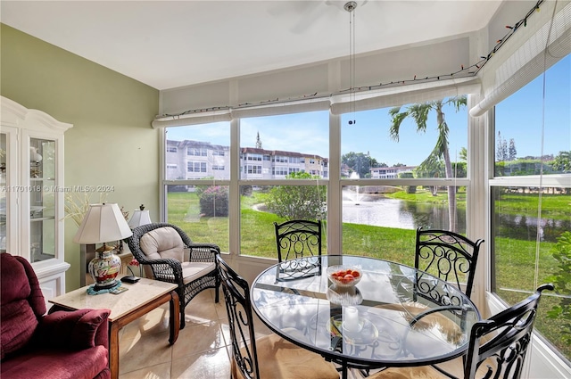 sunroom featuring a water view