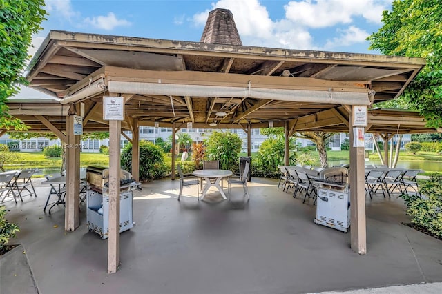 view of patio featuring a gazebo and a water view