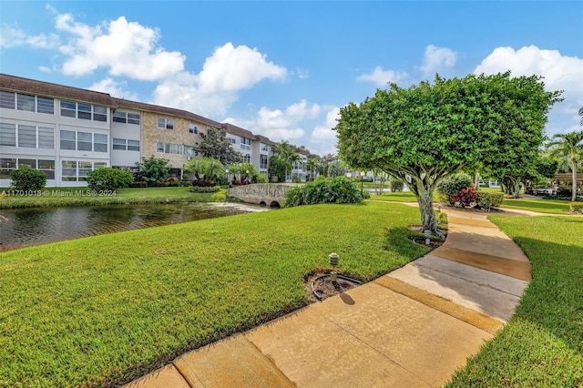 surrounding community with a yard and a water view