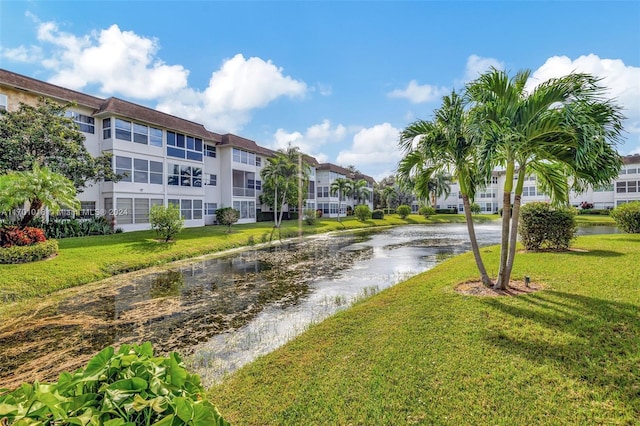 view of home's community with a lawn and a water view