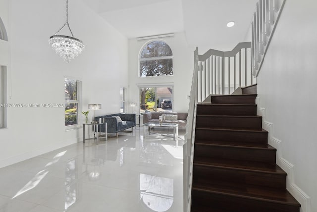 staircase with a notable chandelier and a high ceiling