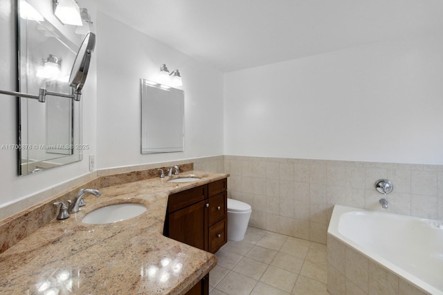 bathroom with toilet, tile walls, vanity, tiled tub, and tile patterned flooring