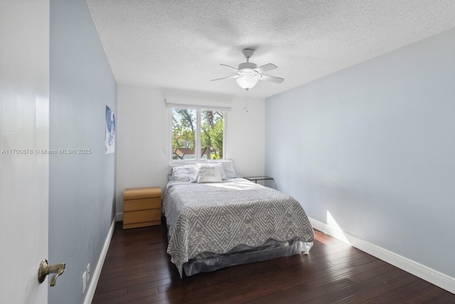 bedroom featuring ceiling fan, dark hardwood / wood-style floors, and a textured ceiling