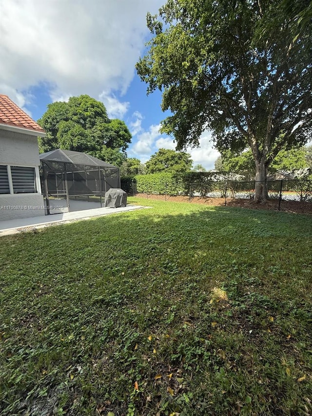 view of yard with a lanai and a patio area