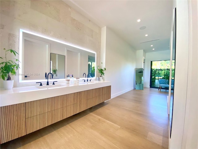 full bathroom featuring recessed lighting, a sink, wood finished floors, baseboards, and double vanity