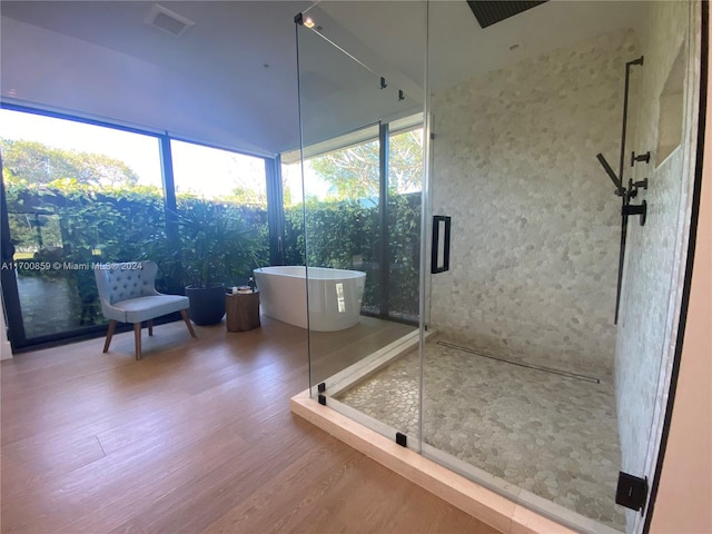 bathroom featuring a soaking tub, wood finished floors, and a shower stall