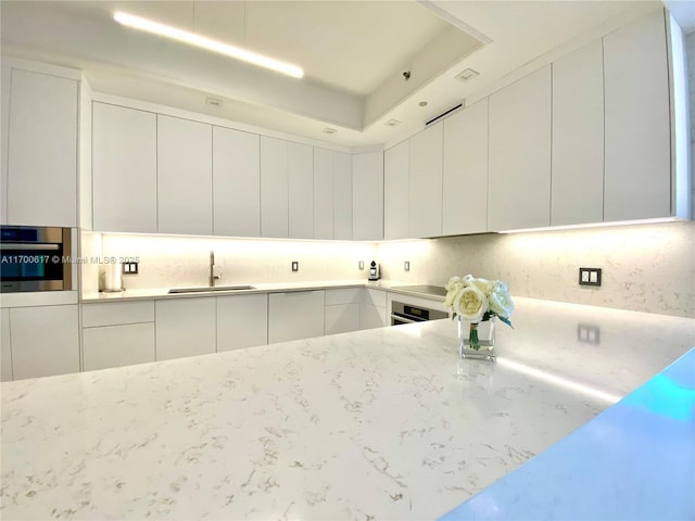 100 S Pointe Dr Unit 1207, Miami Beach, FL 33139 - kitchen with stainless steel oven, a sink, modern cabinets, and white cabinetry