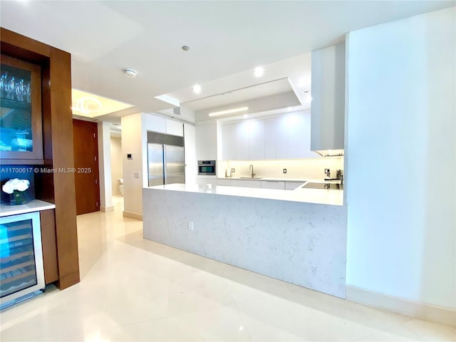 100 S Pointe Dr Unit 1207, Miami Beach, FL 33139 - kitchen with appliances with stainless steel finishes, wine cooler, white cabinets, light countertops, and a tray ceiling