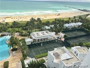 aerial view with a water view and a beach view