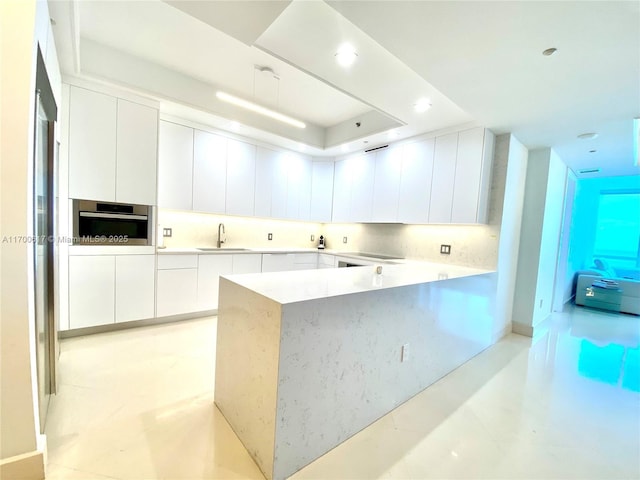 100 S Pointe Dr Unit 1207, Miami Beach, FL 33139 - kitchen with a sink, oven, modern cabinets, white cabinets, and light countertops