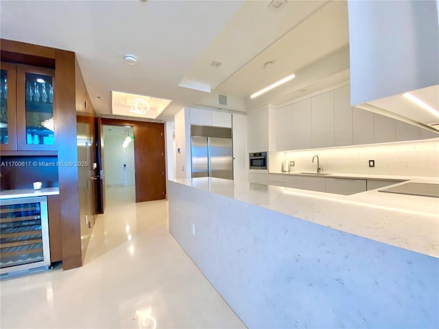 100 S Pointe Dr Unit 1207, Miami Beach, FL 33139 - kitchen with beverage cooler, appliances with stainless steel finishes, modern cabinets, white cabinets, and light stone countertops