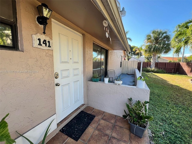 view of exterior entry featuring a yard