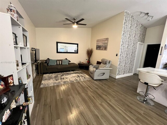 living room featuring ceiling fan and dark hardwood / wood-style floors