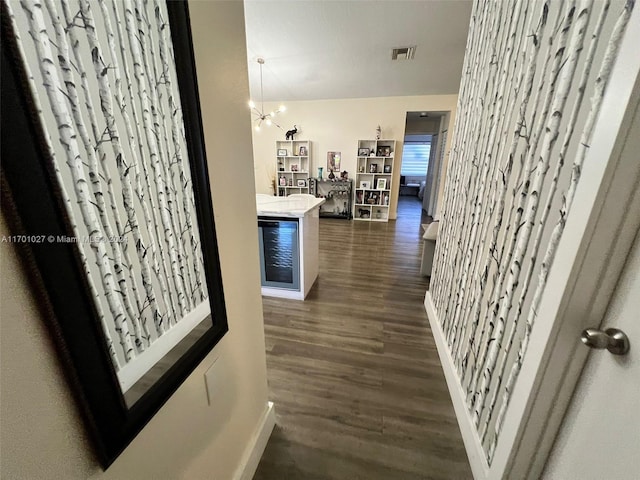 hall with a chandelier and dark hardwood / wood-style flooring