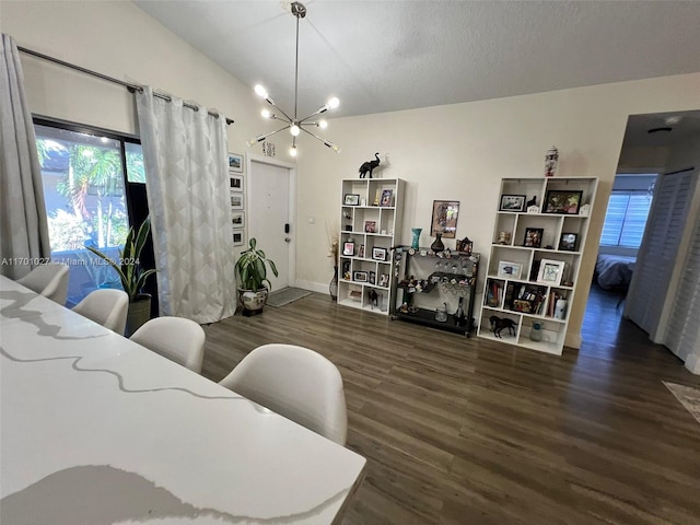 interior space with vaulted ceiling, a textured ceiling, a chandelier, and dark hardwood / wood-style floors