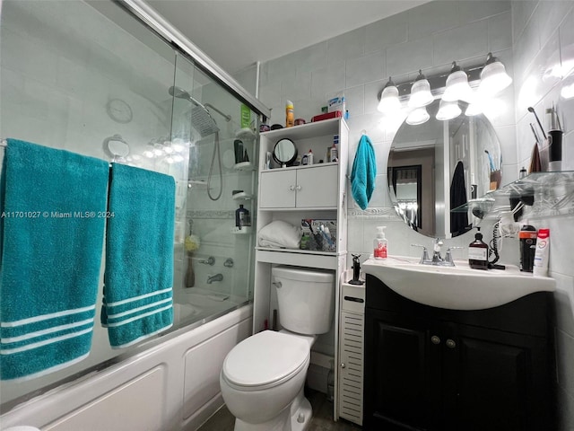 full bathroom featuring backsplash, vanity, tile walls, enclosed tub / shower combo, and toilet