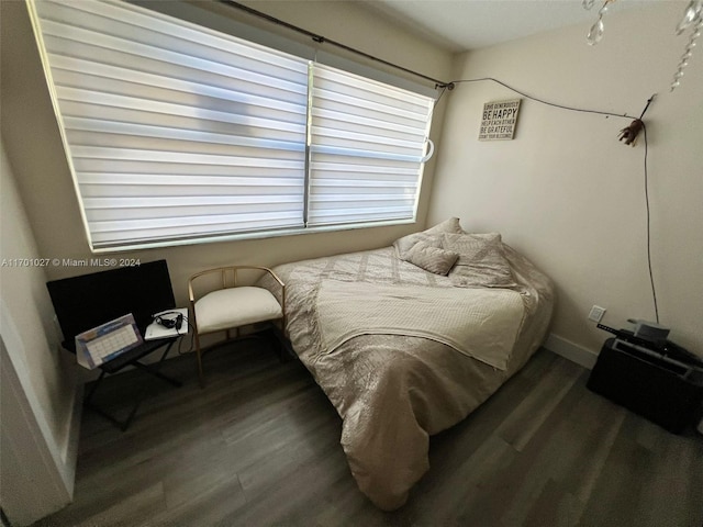 bedroom with dark hardwood / wood-style floors