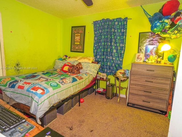 bedroom featuring carpet flooring, ceiling fan, and a textured ceiling