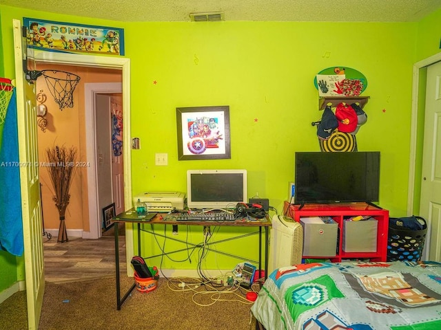 recreation room with carpet and a textured ceiling