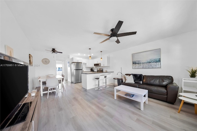 living room with light wood-type flooring and ceiling fan