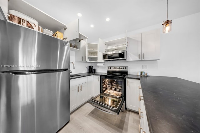 kitchen with white cabinets, light hardwood / wood-style floors, sink, and appliances with stainless steel finishes