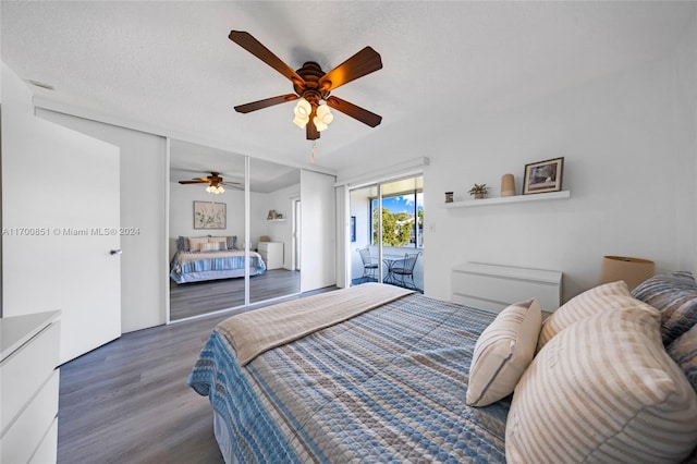 bedroom with ceiling fan, dark hardwood / wood-style floors, a textured ceiling, and access to outside