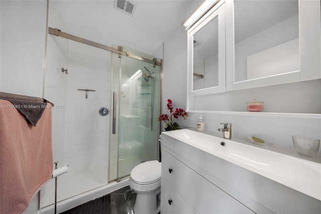 bathroom with a shower with door, vanity, and toilet