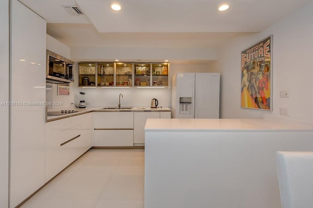 kitchen featuring white cabinetry, sink, white refrigerator with ice dispenser, black electric stovetop, and light tile patterned flooring