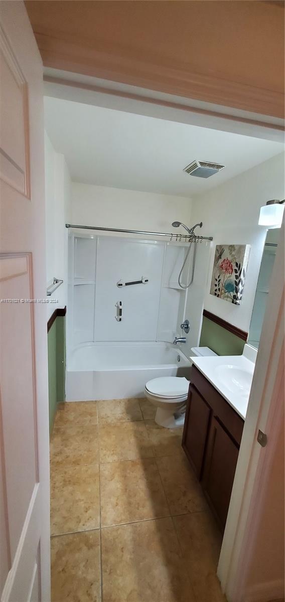 full bathroom featuring shower / tub combination, vanity, toilet, and tile patterned floors