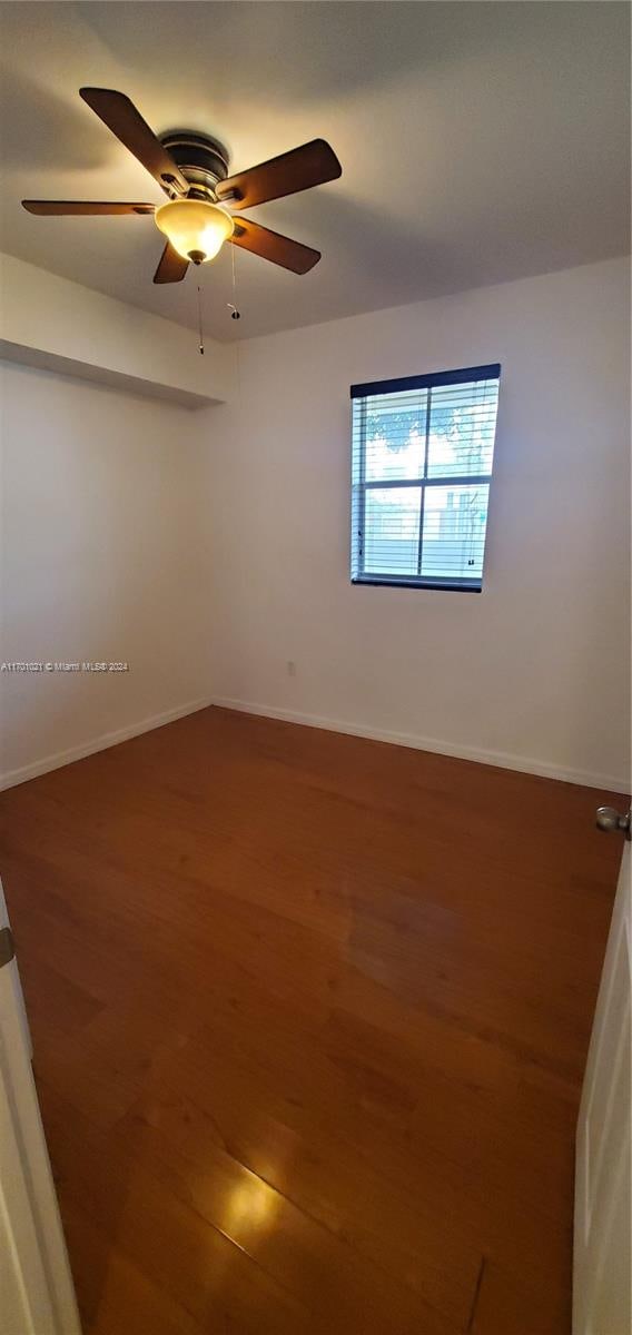 empty room with wood-type flooring and ceiling fan