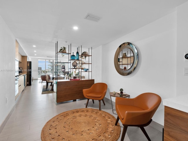 living area with expansive windows, visible vents, and recessed lighting